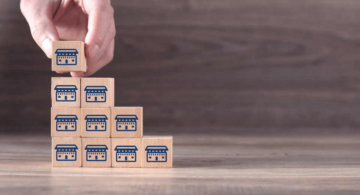 Hand stacking wooden blocks with stores printed on the front of each